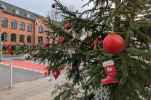 Man sieht einen Ausschnitt vom Baum am Haarmannplatz mit verschiedenen Sorten des Baumsschmucks im Fokus.