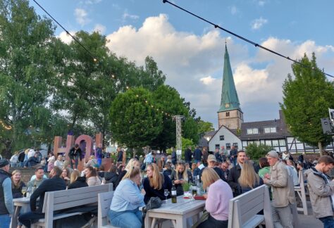 Blick vom Weserkai auf einen gut besuchten Duftgarten mit der Lutherkirche im Hintergund.