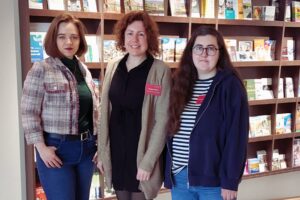 von links: Viktoria Raab, Isabell Adam und Franziska Salowsky stehen vor der Prospektwand in der Tourist-Info.